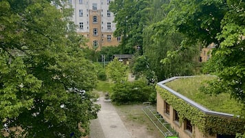 Un patio con un sendero, bicicletas y un edificio con techo verde.