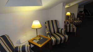 A hotel room with striped armchairs, a small table with a lamp, and a visible staircase leading to another level. - Pension Freiraum Guesthouse Berlin (Berlin)