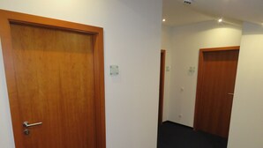 A hallway with wooden doors and a dark carpeted floor. - Pension Freiraum Guesthouse Berlin (Berlin)