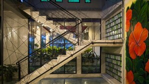 A modern interior with a staircase, large windows, and a mural of flowers. - Maryo Resort Chiangrai (Chiang Rai)