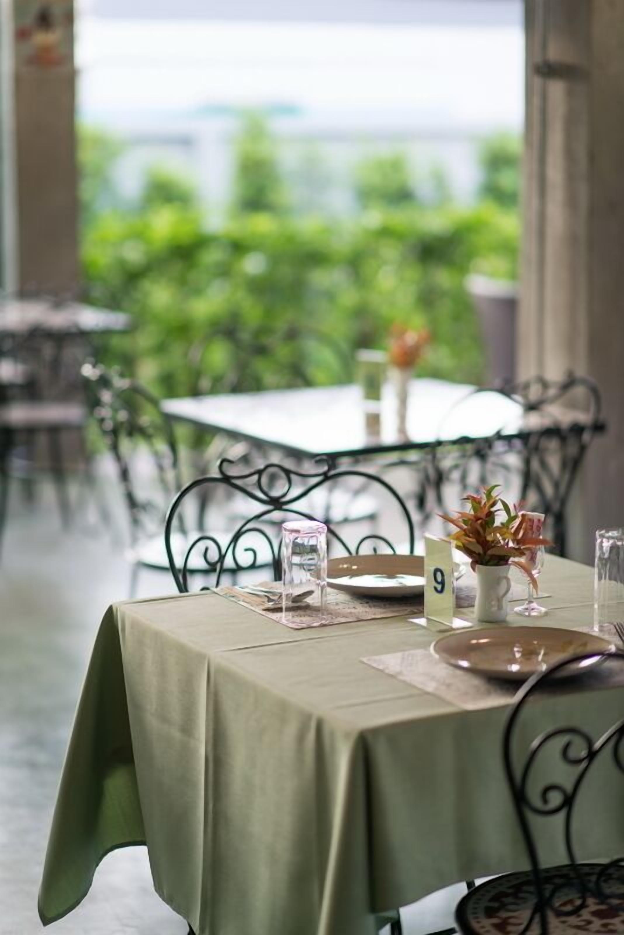A table set for dining with a view of greenery outside.