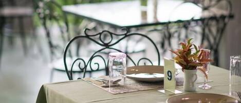 A table set for dining with a view of greenery outside.