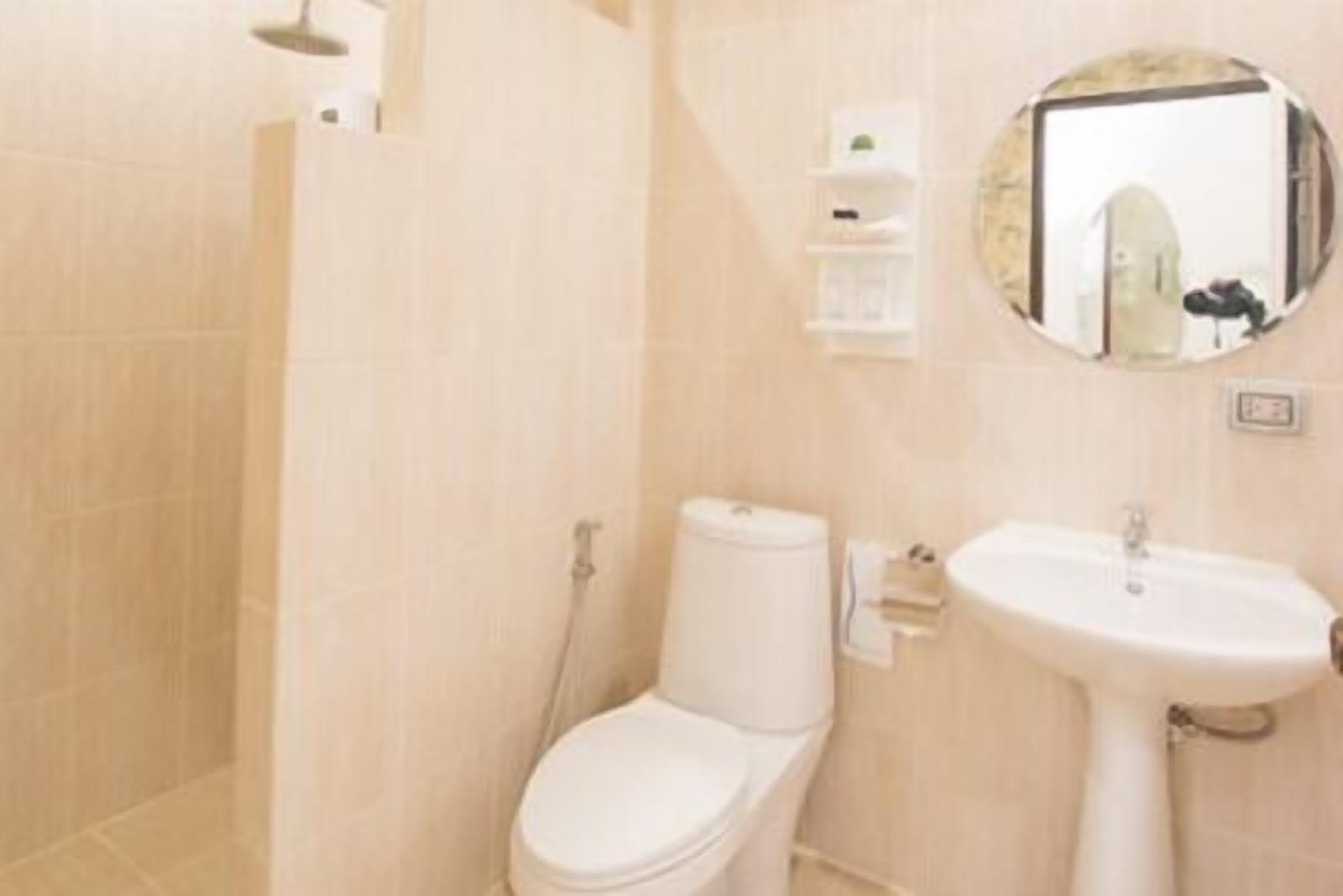 A bathroom with a toilet, sink, and shower.