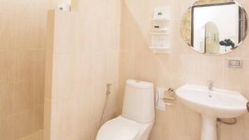 A bathroom with a toilet, sink, and shower.