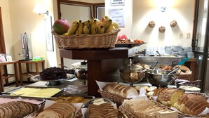 A buffet with various food items including bread, fruits, and desserts. - Hotel Ilhasul (Florianópolis)