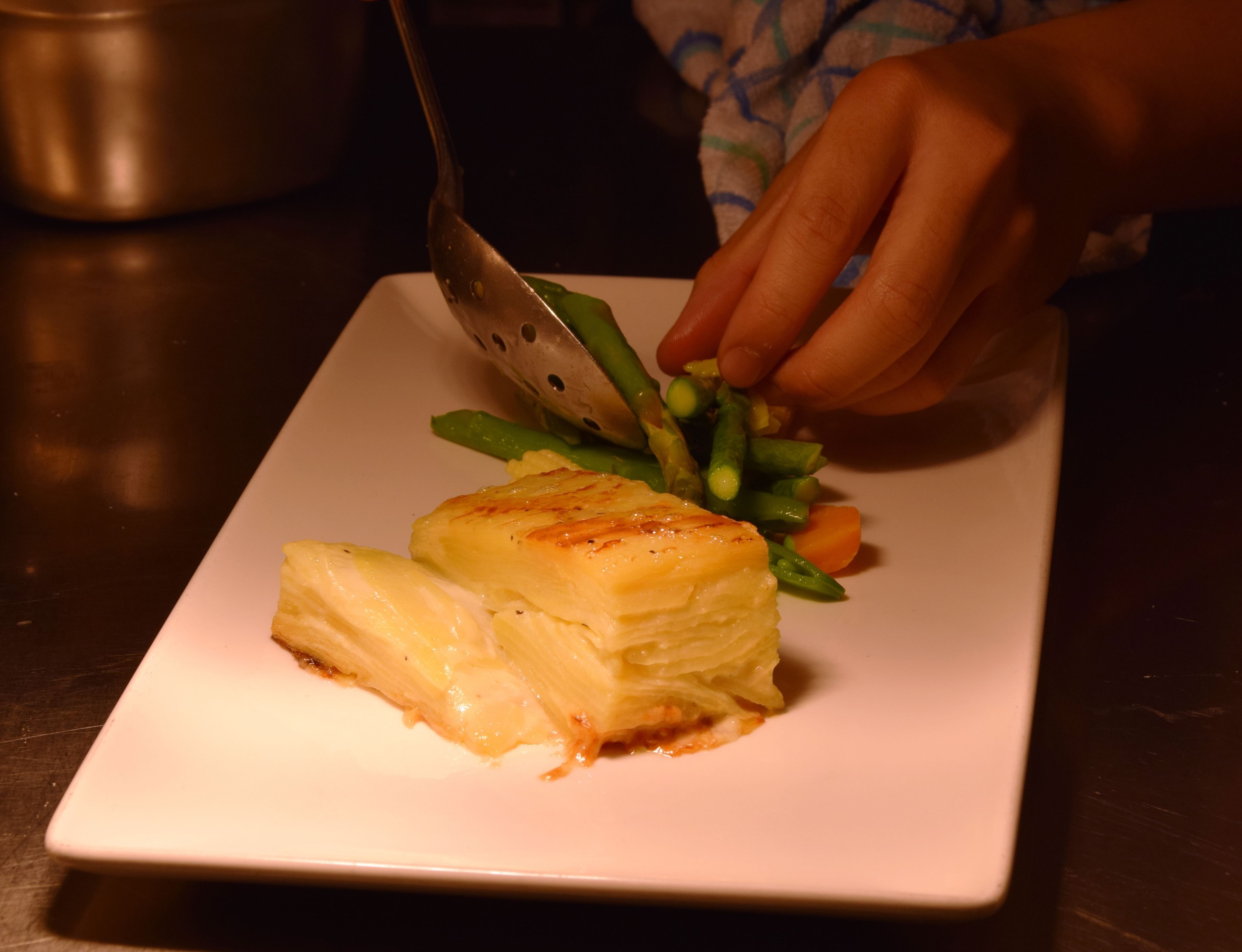 A person cutting a dish with a fork.