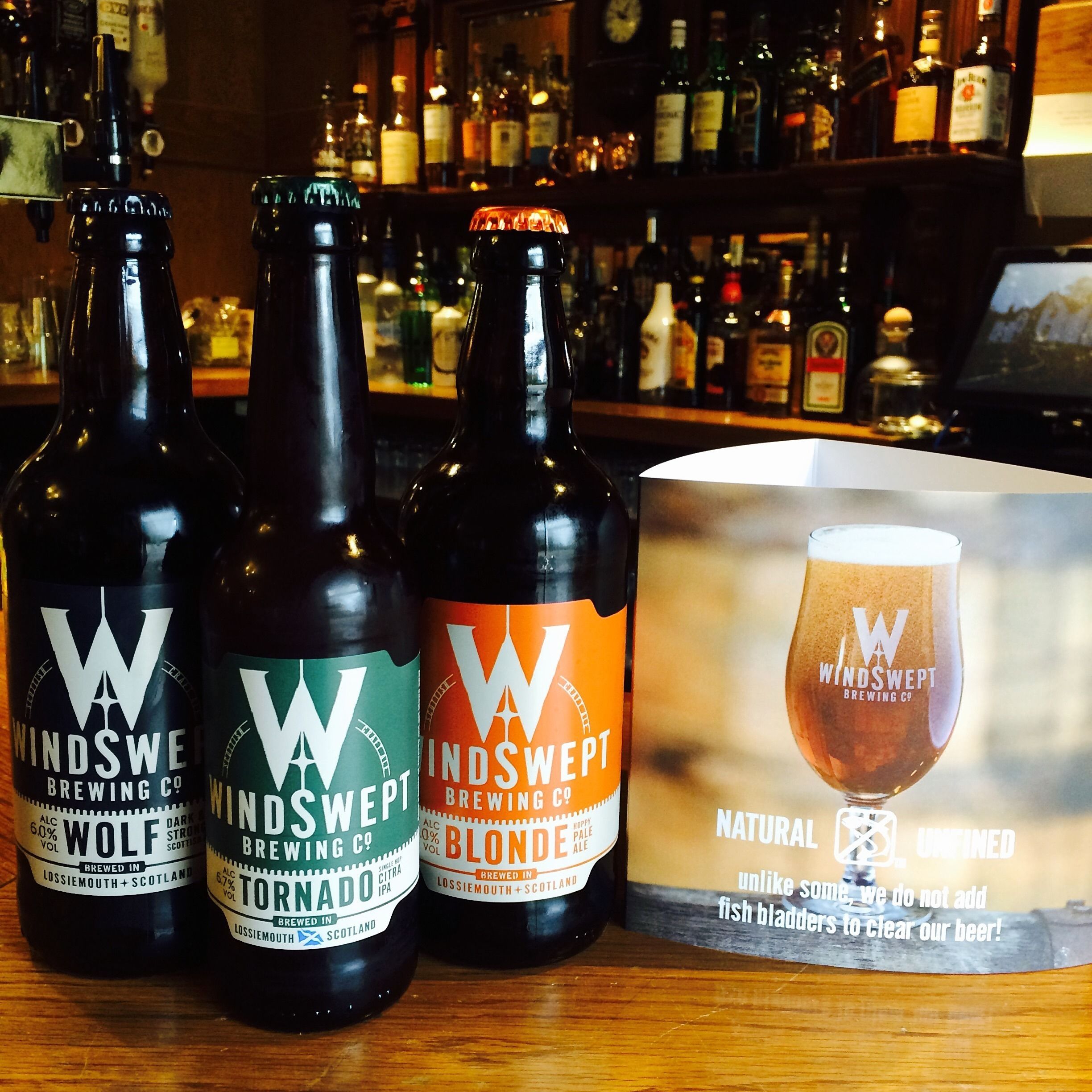 Three bottles of Windswept Brewing Co. beer and a box of Windswept Natural Unfiltered beer.