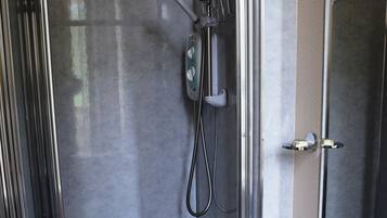 A modern bathroom with a glass-enclosed shower, a white sink, and a mirror.