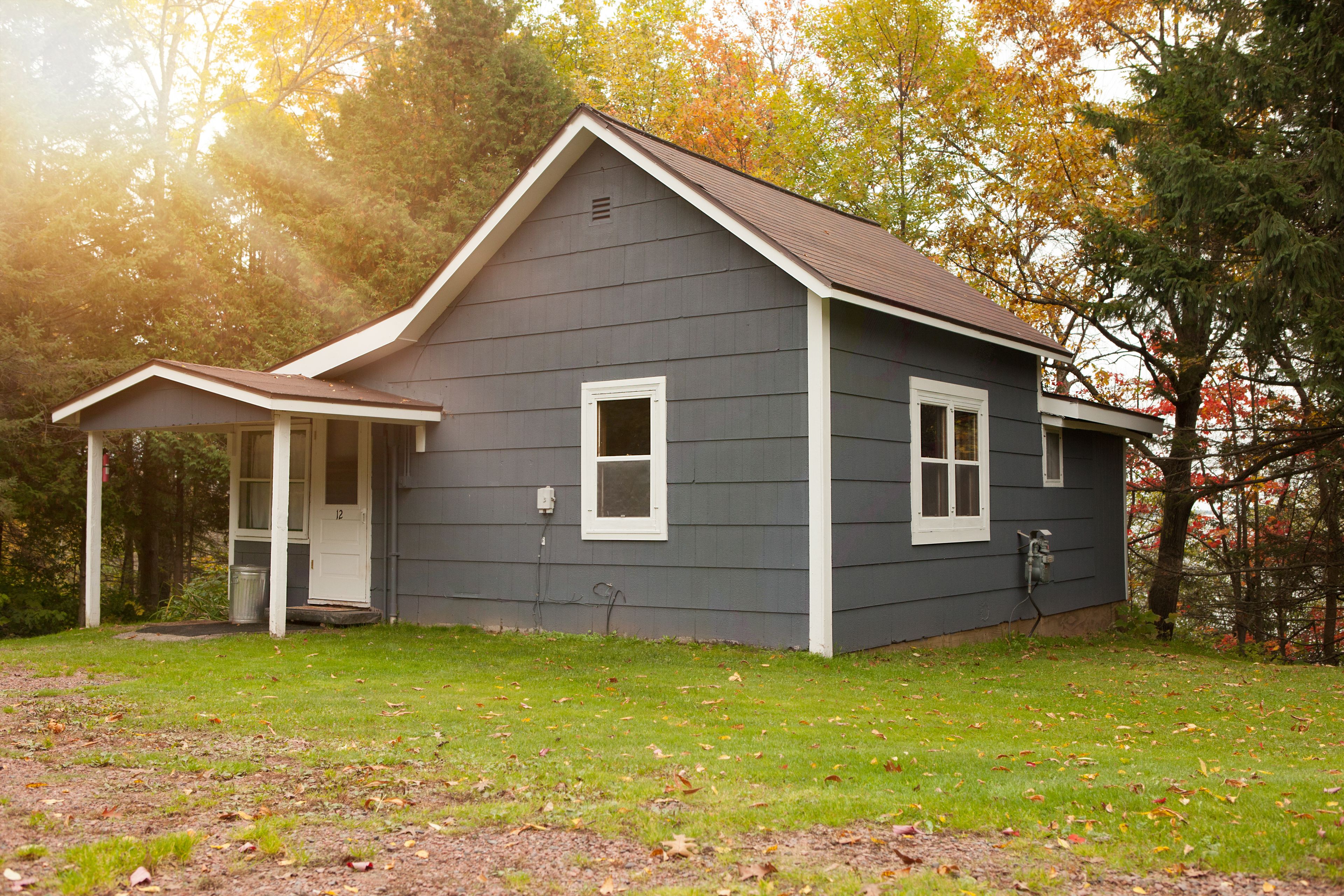 A two-story house with a porch, a front door, and a small front yard.