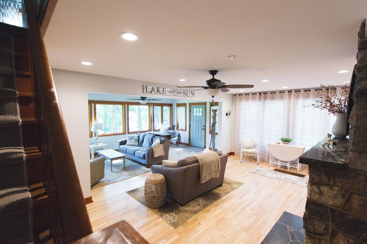 A spacious living room with a fireplace, a sofa, and a dining area with a table and chairs.