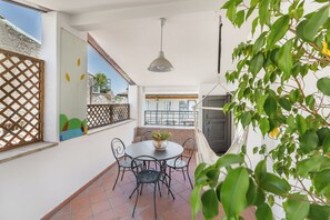 Un patio con una mesa redonda y sillas, una lámpara colgante y vistas del paisaje urbano.