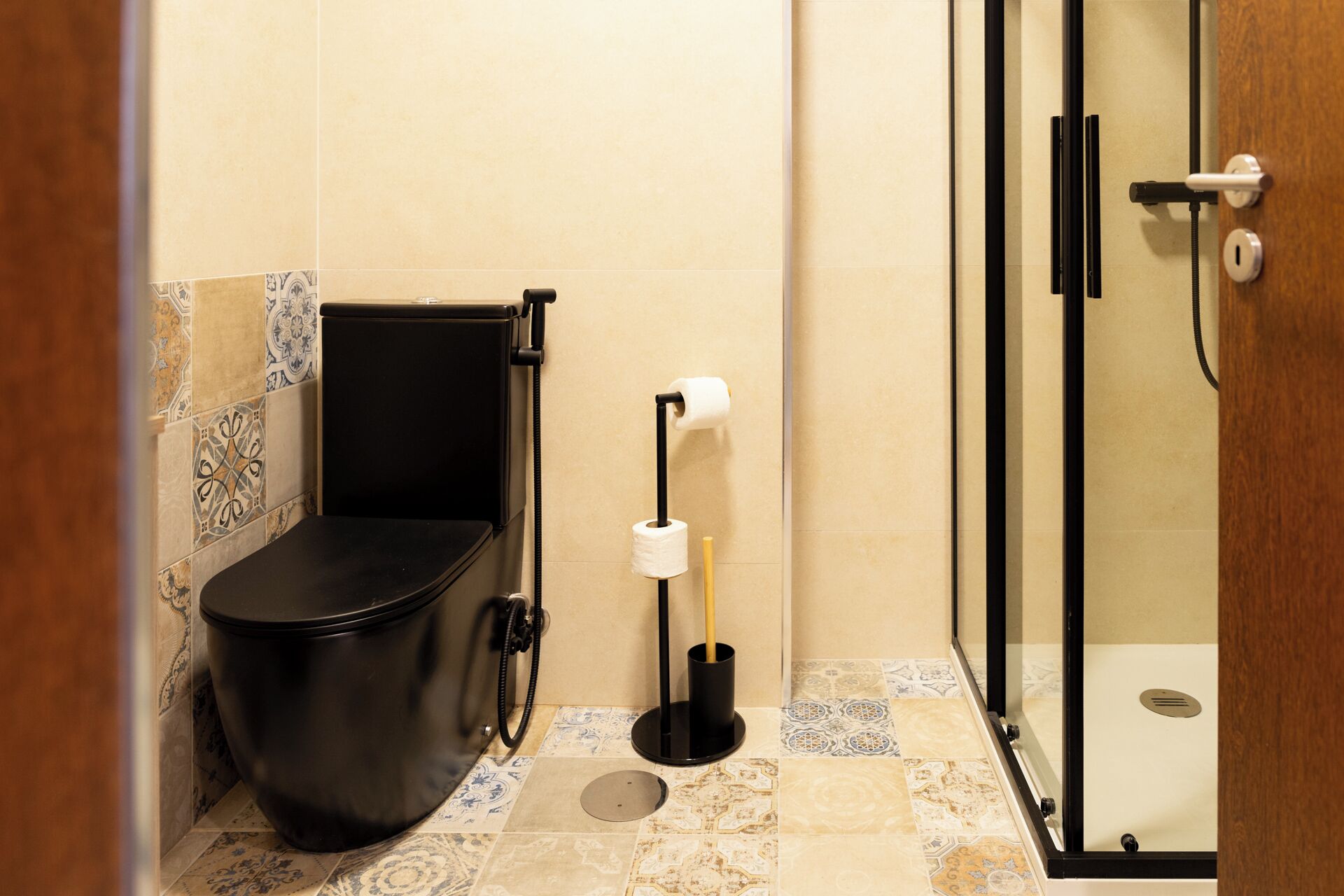 Un baño pequeño con inodoro, ducha y soporte para papel higiénico.