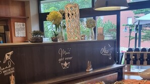 Een buffetgedeelte met diverse eetmogelijkheden, waaronder vleesschotels en een schaal augurken.