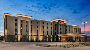 A hotel with a modern design, featuring a prominent entrance and a well-lit facade. - Hampton Inn & Suites Mason City (Mason City)