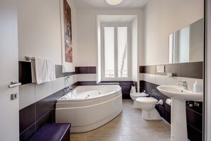 Un baño moderno con una bañera independiente, un inodoro y un lavabo.