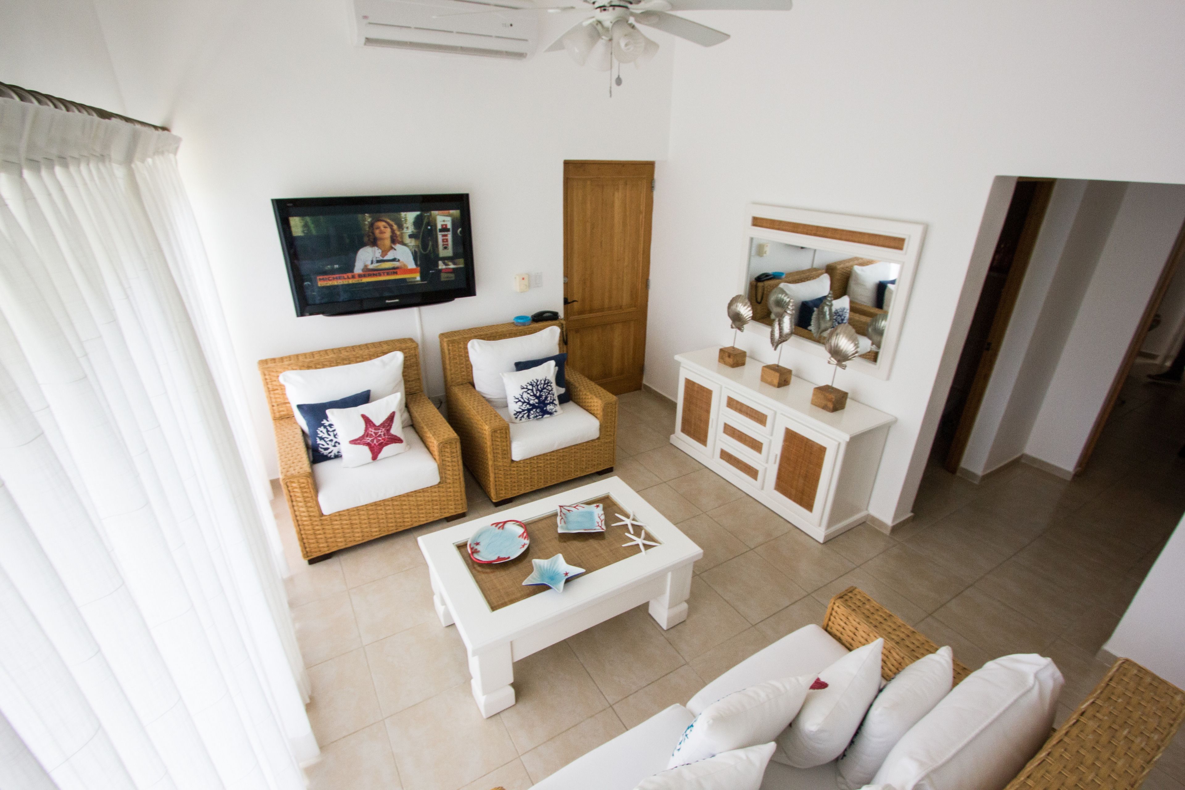 A living room with a television, two sofas, a coffee table, and a mirror.