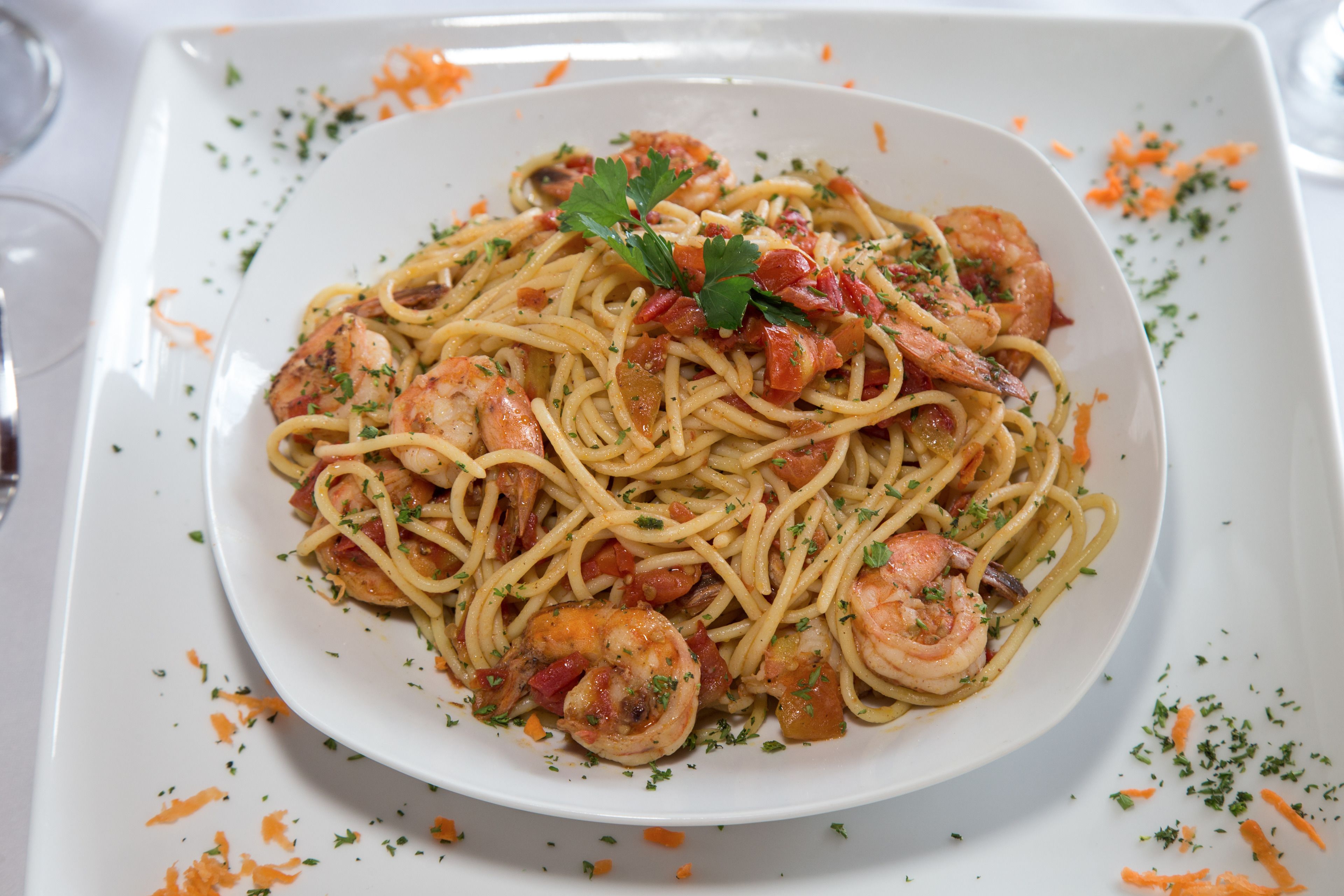 Un plato de espagueti con camarones y verduras.