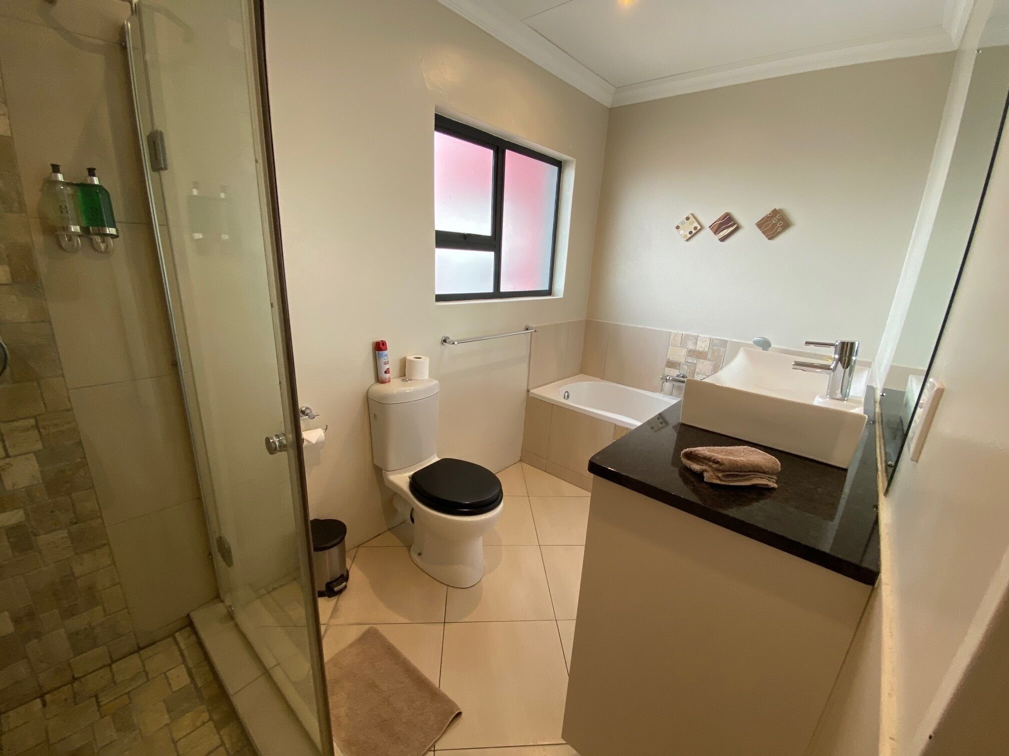 A modern bathroom with a shower, toilet, and bathtub.