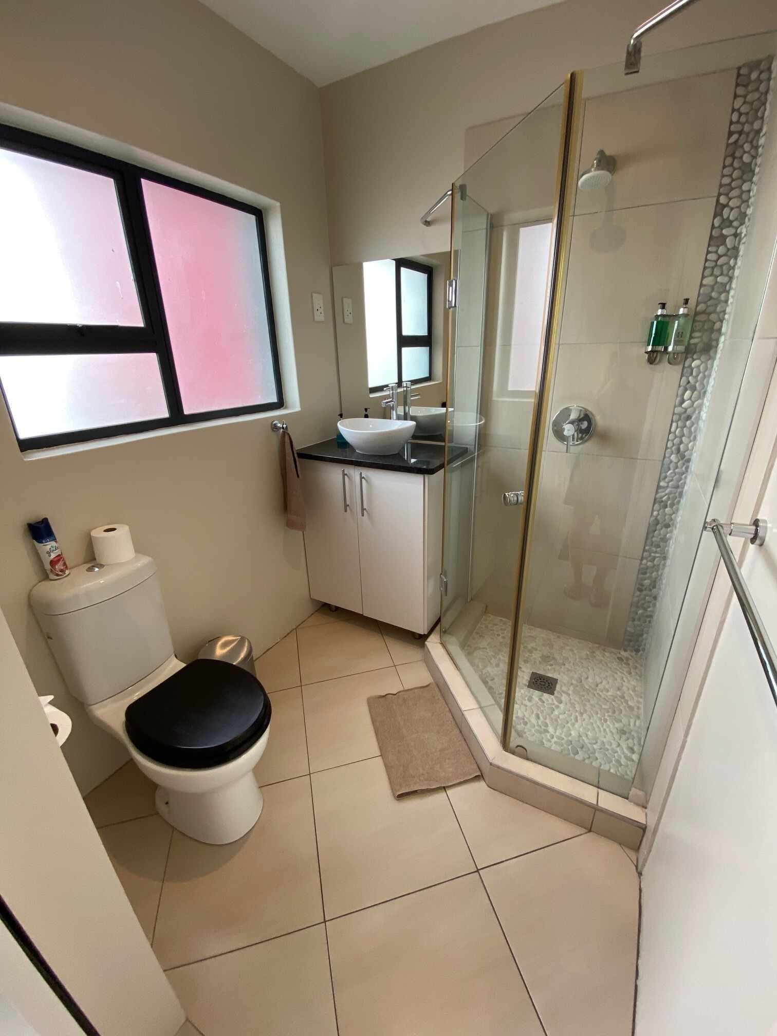 A bathroom with a toilet, sink, and shower.