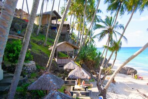 Rannalla, valkoista hiekkaa, aurinkotuoleja, aurinkovarjoja