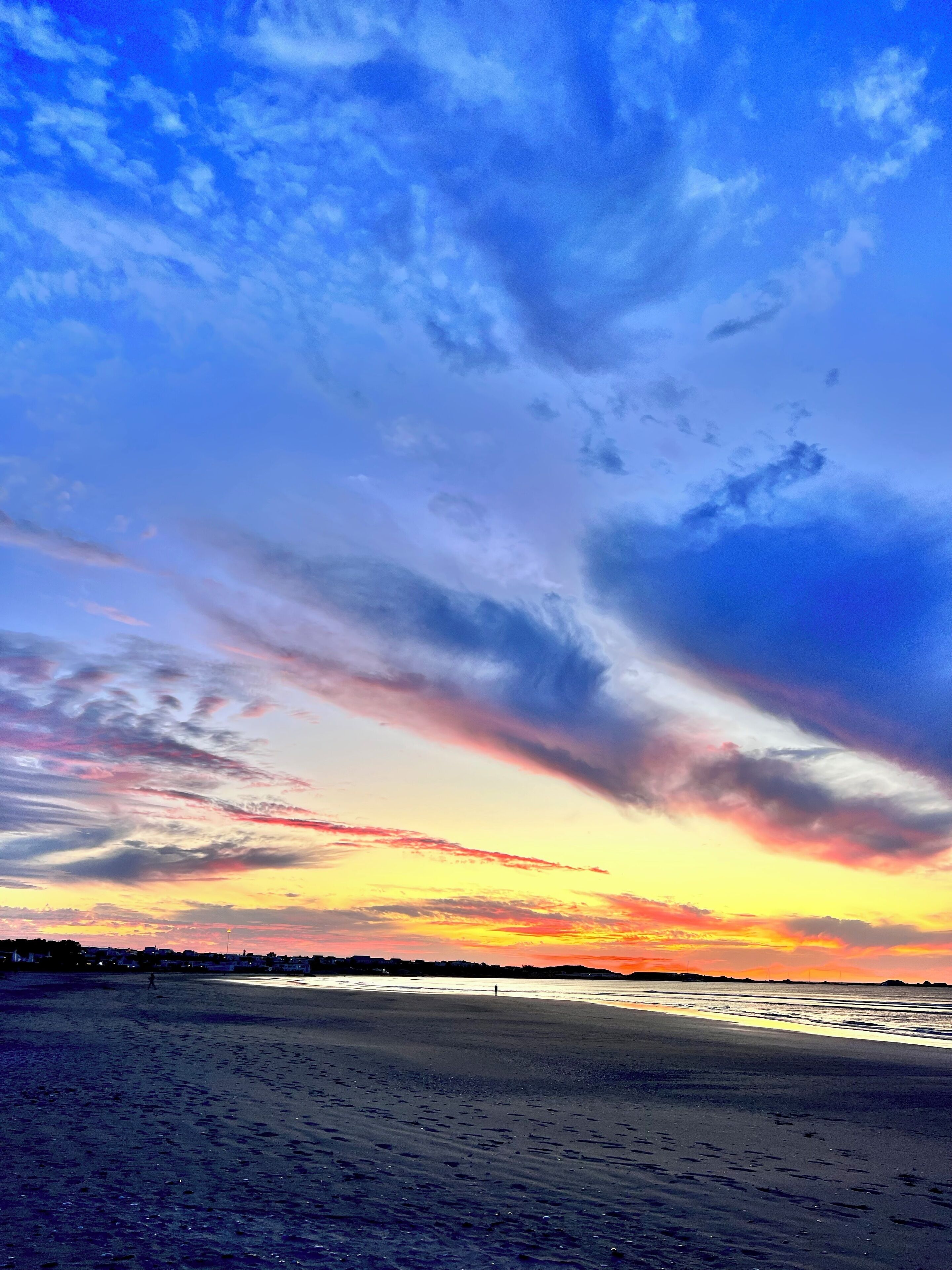 Uma praia com um pôr do sol e nuvens.