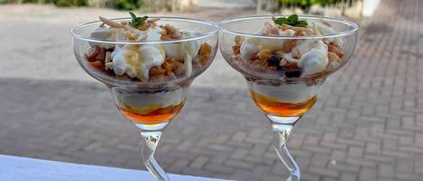 Two dessert glasses on a white ledge with a street view in the background.