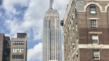 A high-rise building with a spire, surrounded by other buildings.