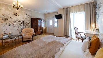 A hotel room with a large bed, a desk, a chair, a television, and a wall with a unique design.