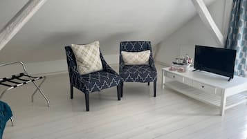 A room with two armchairs, a white TV stand, and a small table.