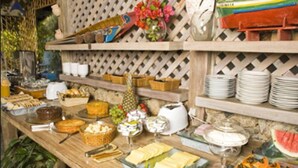 A buffet table with various food items and utensils.