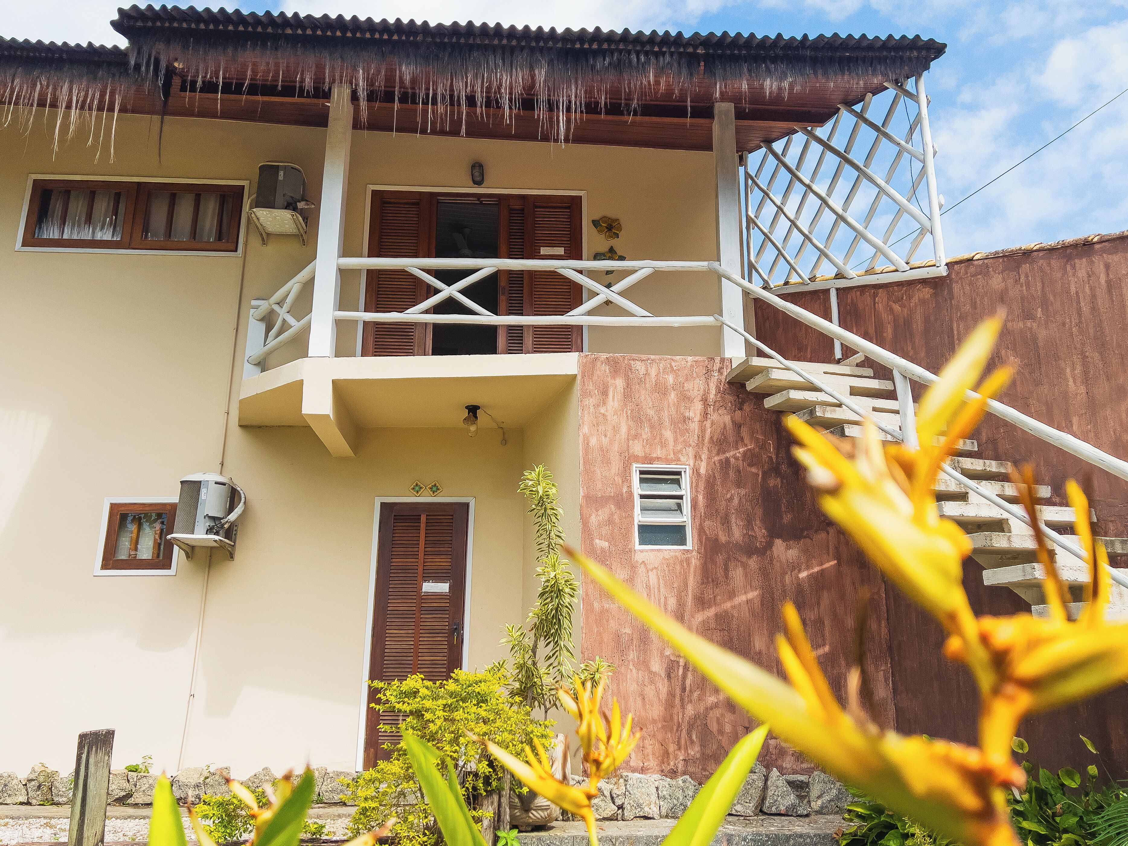 A two-story building with a balcony, a staircase, and a door.