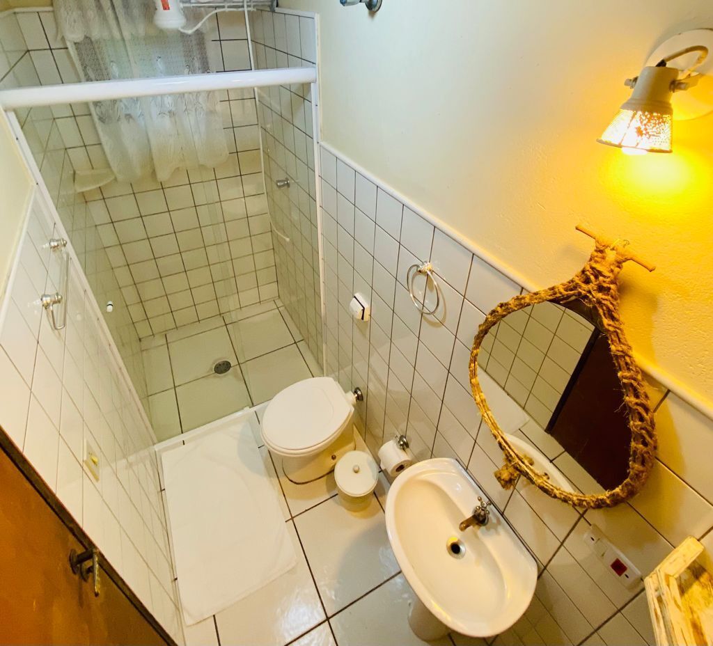 A bathroom with a shower, toilet, and sink.