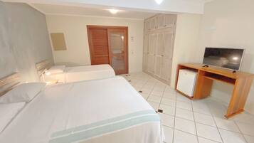 Une chambre d’hôtel avec deux lits, une télévision, une armoire et un bureau.