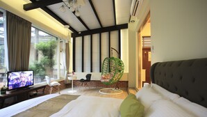 A hotel room with a bed, a television, a chair, and a hanging chair. - Zhen Shan Zhuang B&B (Yuanshan)