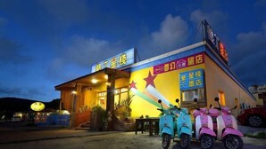 A building with a signboard and a brightly lit exterior. - Kstar 888 Bed and Breakfast (Hengchun)