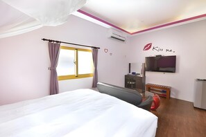A hotel room with a bed, a television, a desk with a chair, and a wardrobe. - Kstar 888 Bed and Breakfast (Hengchun)