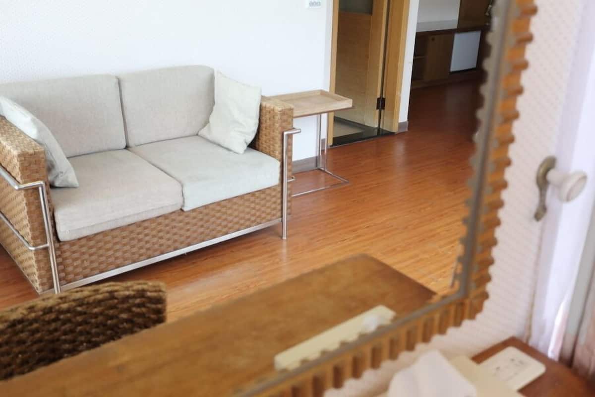 A modern living room with a sofa, a small table, and a wooden floor.