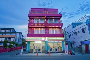 A multi-story building with a ground-level entrance, large windows, and a visible sign. - Pin Ciao Hotel (Hengchun)