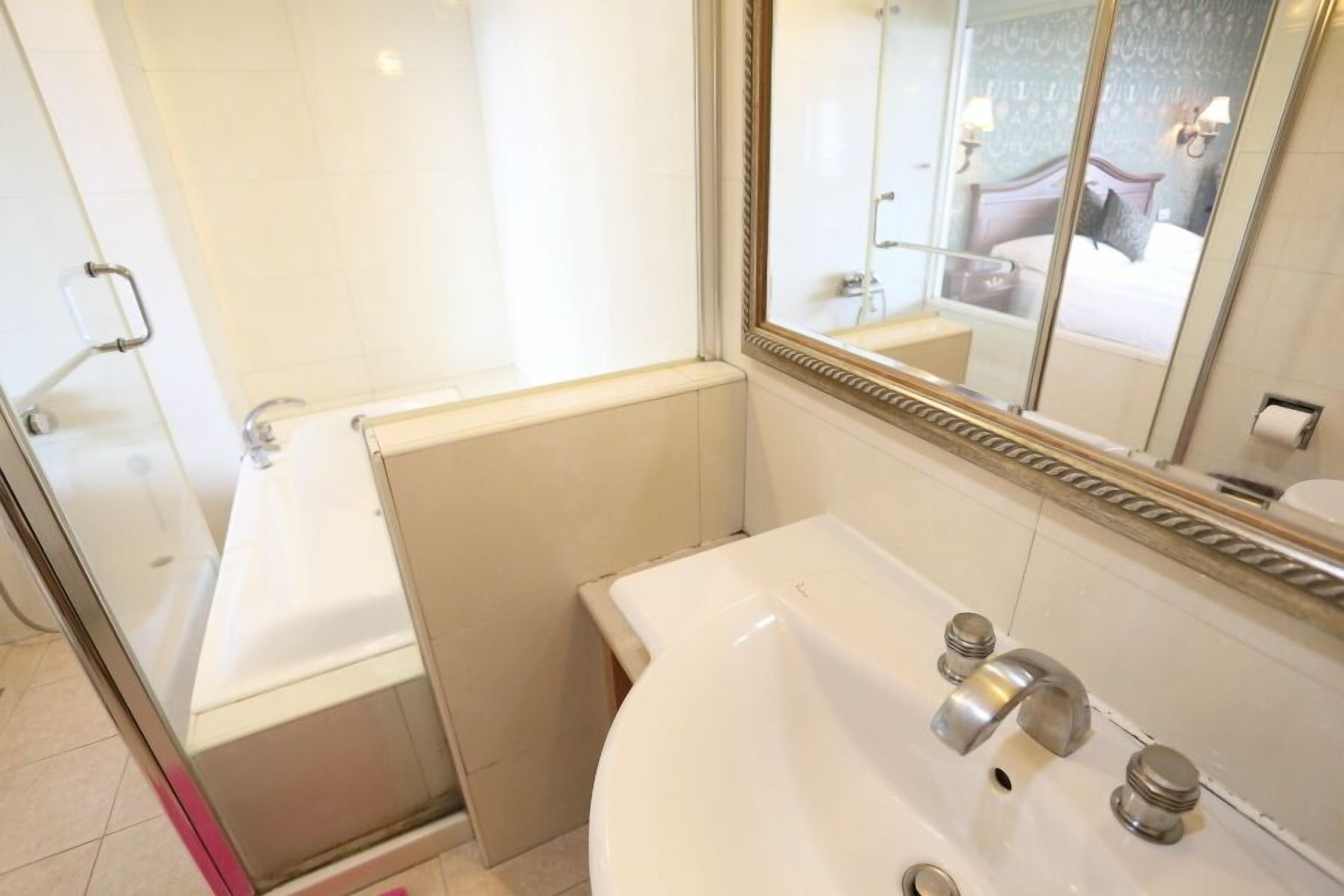 A bathroom with a bathtub, a sink, and a shower.