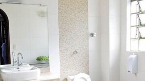 Un baño moderno con un lavabo blanco, un inodoro y un espejo.