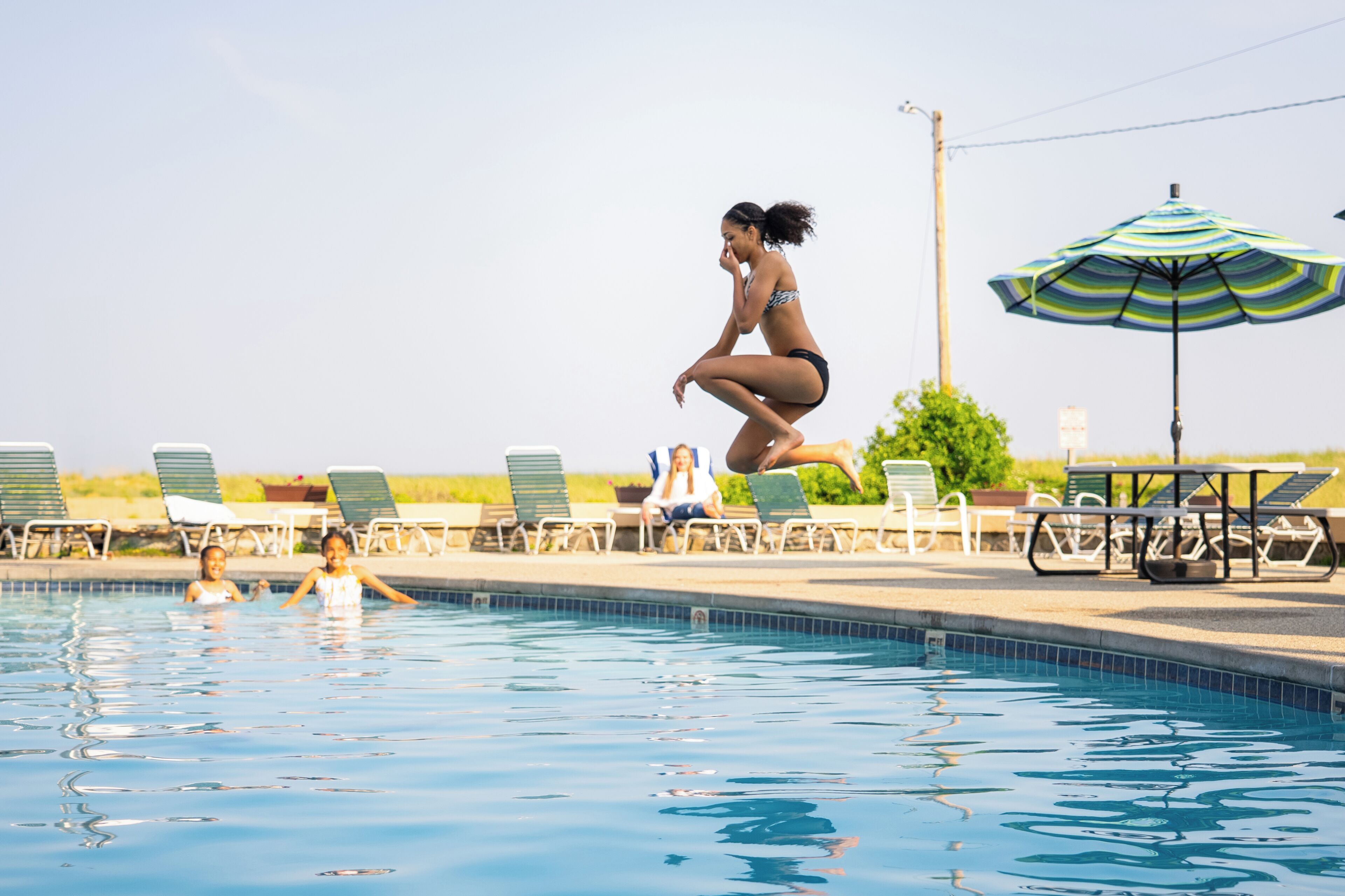 Una piscina con sillas de descanso y una sombrilla.