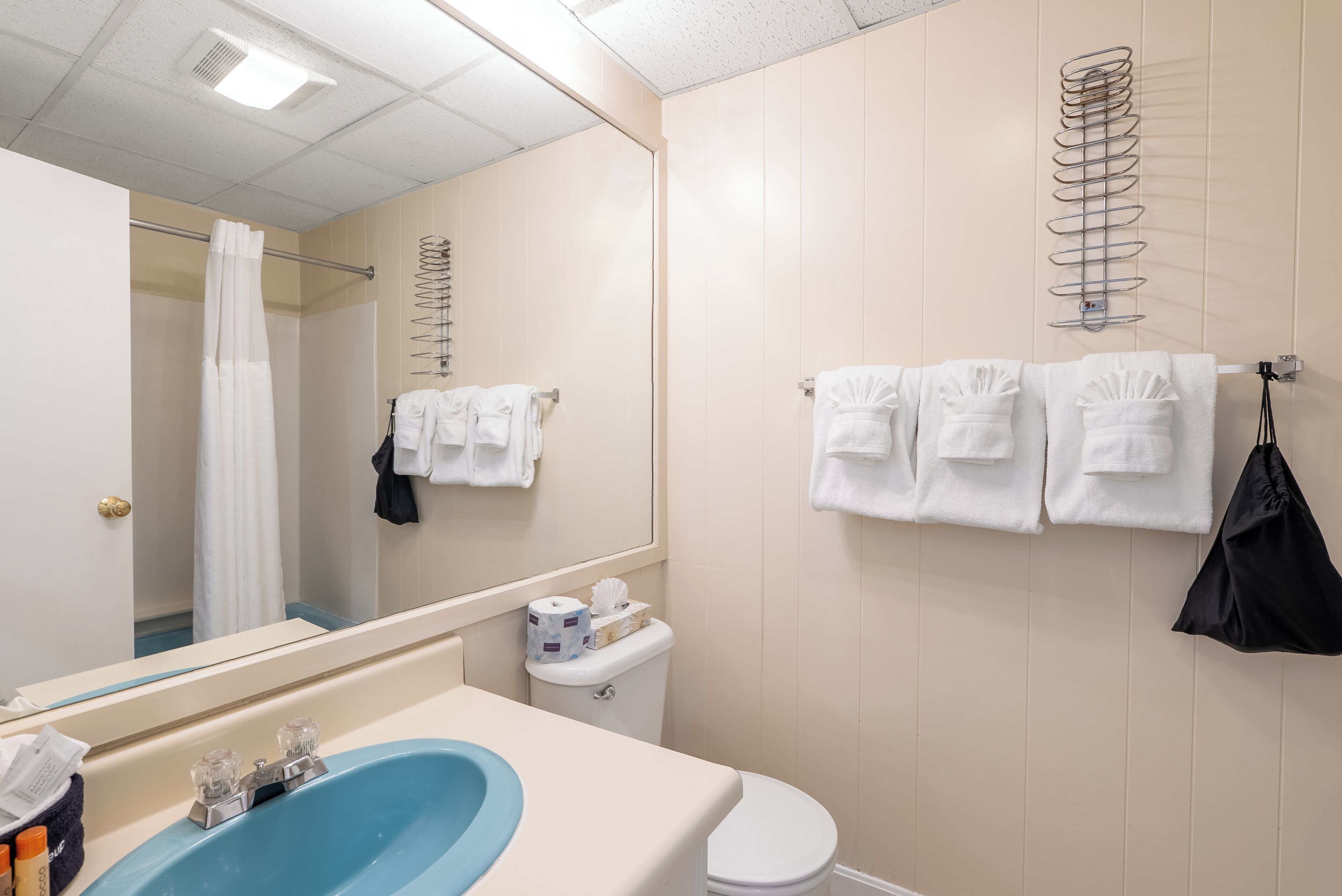 Un baño con lavamanos, inodoro y perchero para toallas.