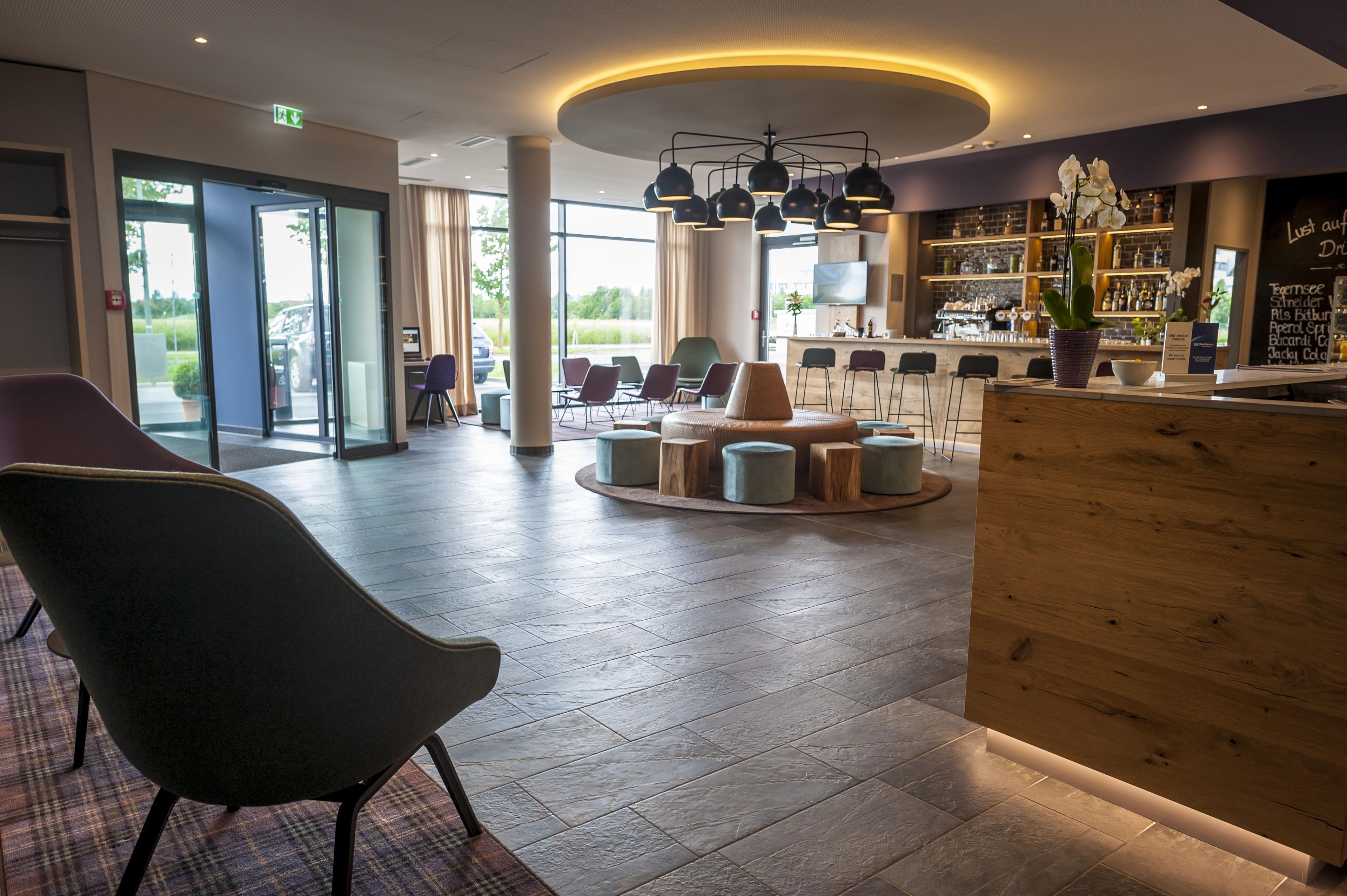 Eine moderne Lobby mit Empfangsbereich, Sitzgelegenheiten und einer Bar.