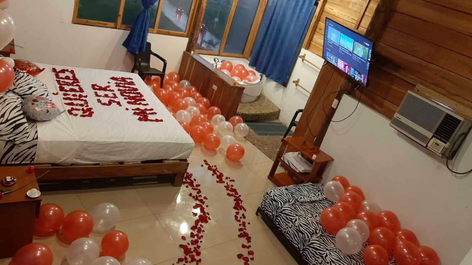 Una habitación con cama, televisión y ventana.