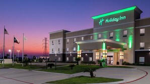Un hotel Holiday Inn con una fachada moderna, múltiples accesos y una entrada bien iluminada.