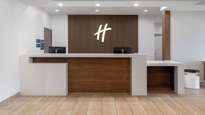 Un moderno mostrador de recepción con un panel de madera como fondo y un gran símbolo de hashtag.