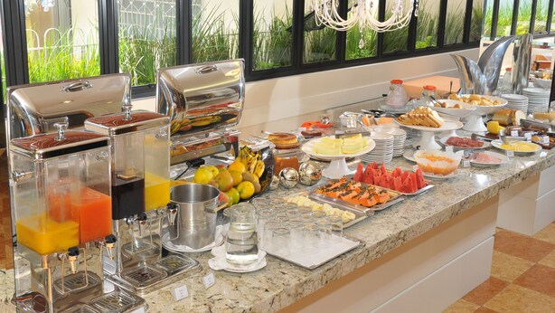 A buffet with various food items and a juice bar. - Cosmos Hotel (Caxias do Sul)