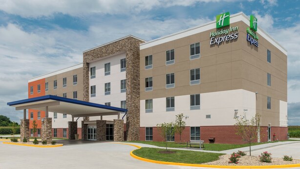 A Holiday Inn Express building with a modern design, featuring a covered entrance and a parking lot.