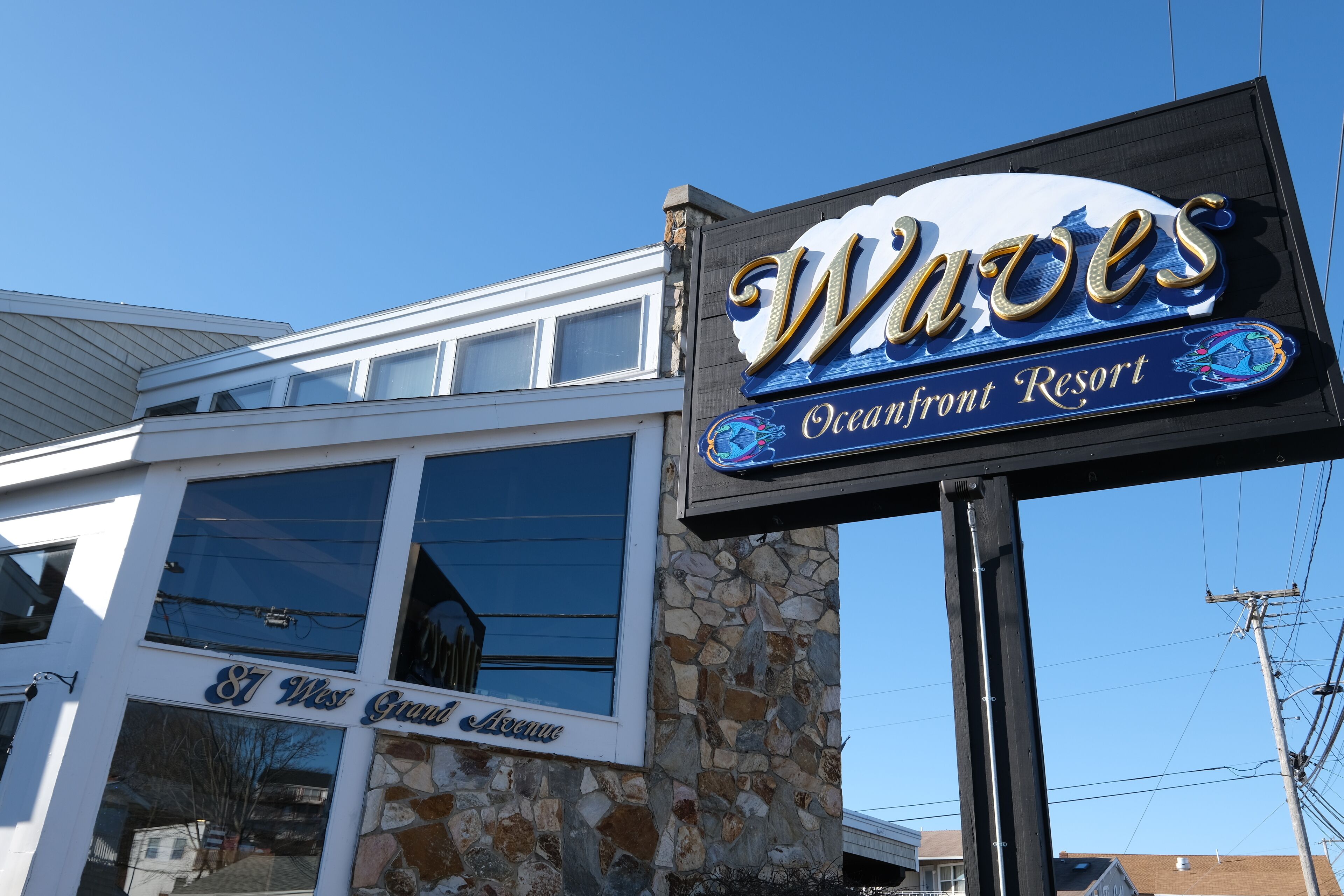 A building with a sign that reads "Waves Oceanfront Resort."