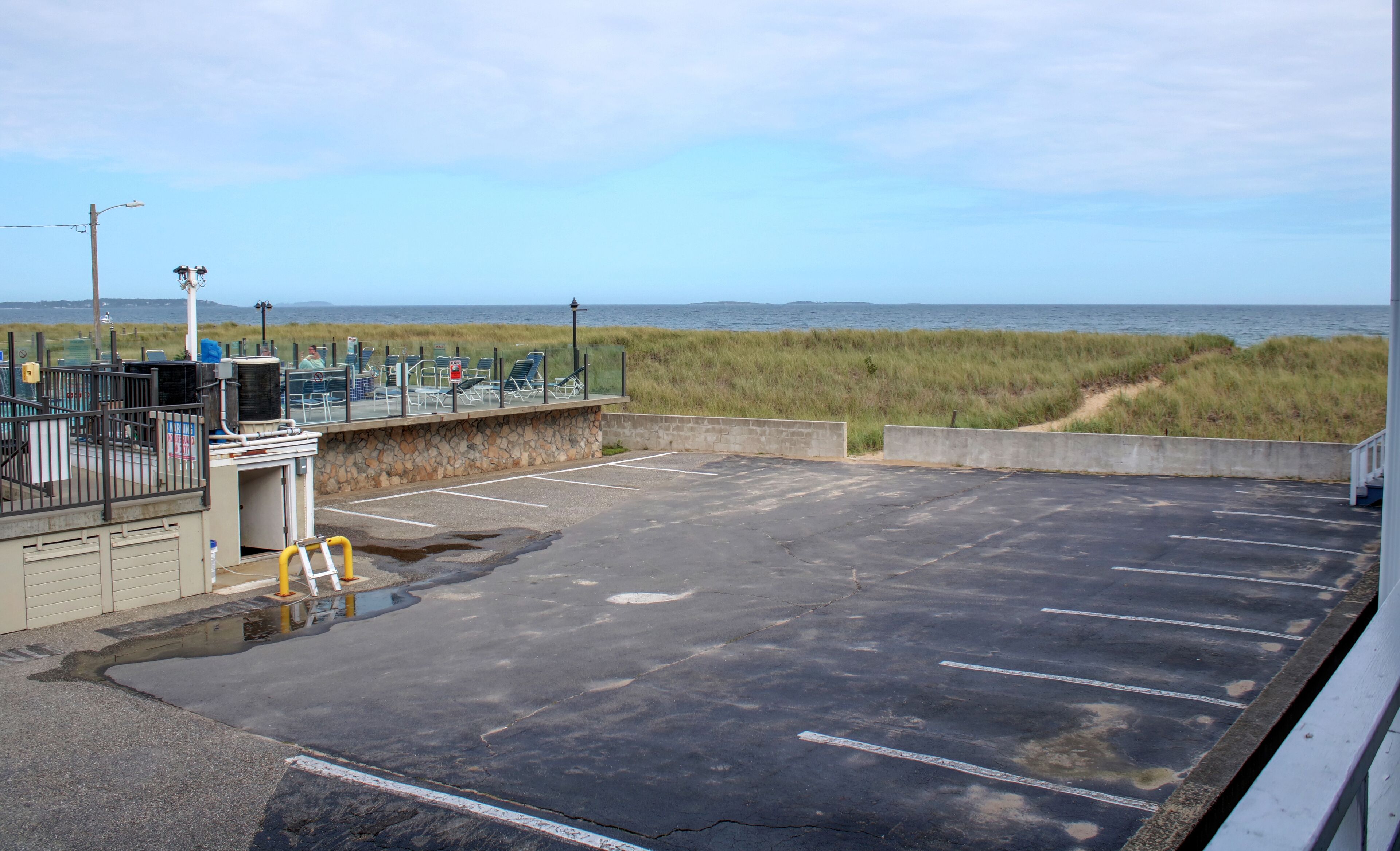 Un espace de stationnement offrant une vue sur la plage et l’océan.